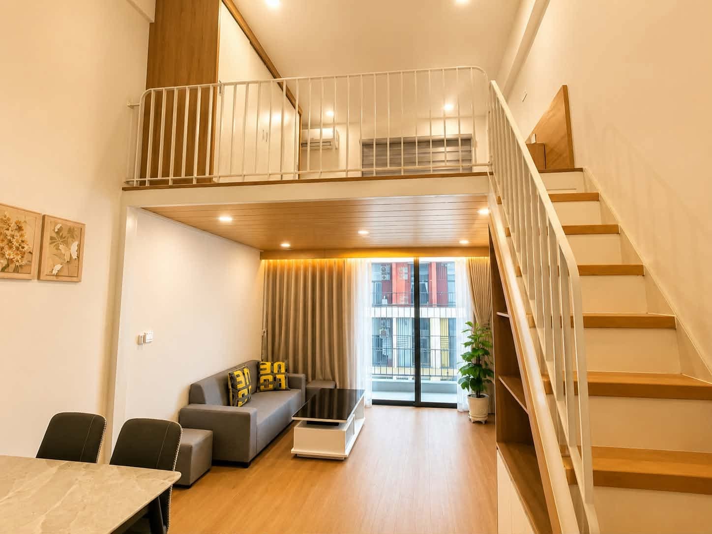 A403A-2 — Toàn cảnh studio gác lửng với cầu thang gỗ và trần thông tầng