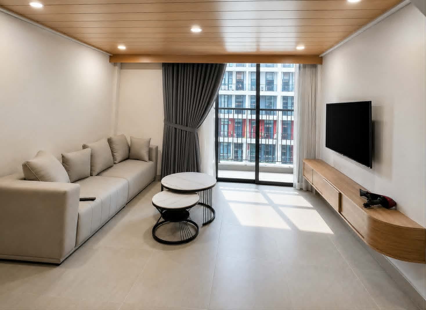 A623 — Phòng khách sofa kem dài, bàn trà mặt đá và smart TV trên kệ gỗ