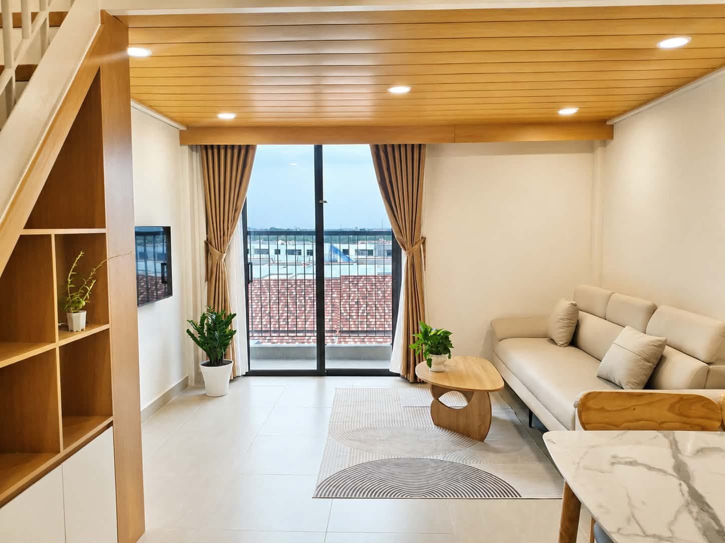 A205 — Phòng khách sofa da kem bên ban công kính lớn view thoáng