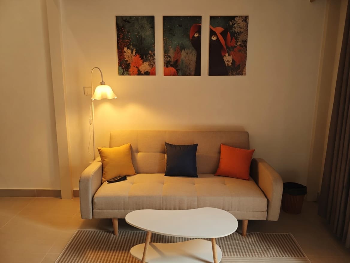 A403A — Góc sofa kem với đèn vàng ấm và tranh treo tường