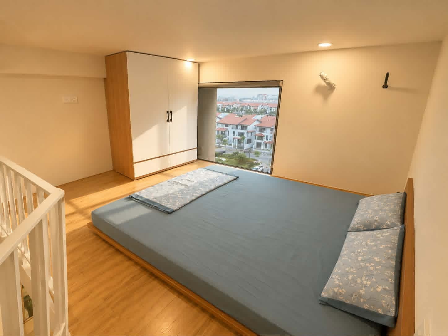A607 — Phòng ngủ gác lửng giường đôi thấp, tủ áo và cửa sổ view khu biệt thự mái ngói
