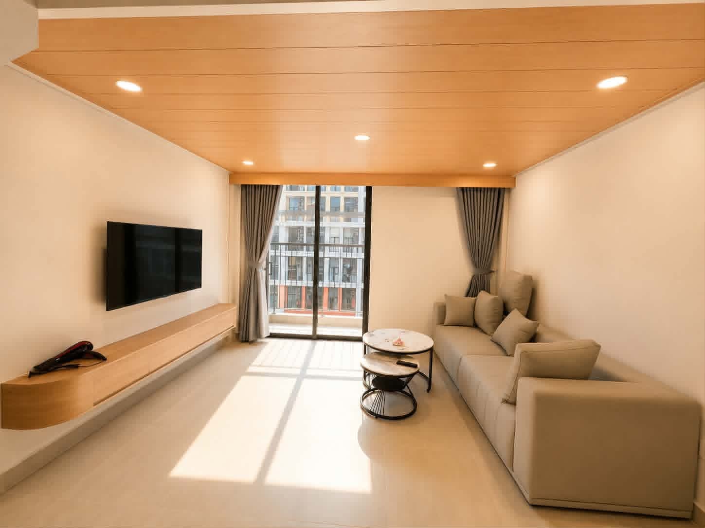 A624 — Phòng khách sofa kem cỡ lớn, bàn trà đôi mặt đá và smart TV trên kệ gỗ dài